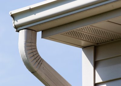 The Gutter Guy - Beige downspout connected to gutter